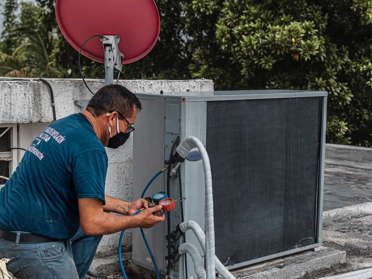 Technician servicing a refrigeration condensing unit